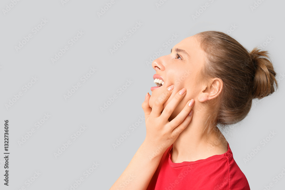 Beautiful young woman suffering from toothache on grey background Beautiful young woman suffering from toothache on grey background