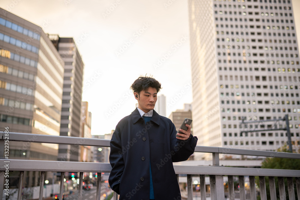Businessman Using Cellphone On Bridge Surrounded by Skyscrapers