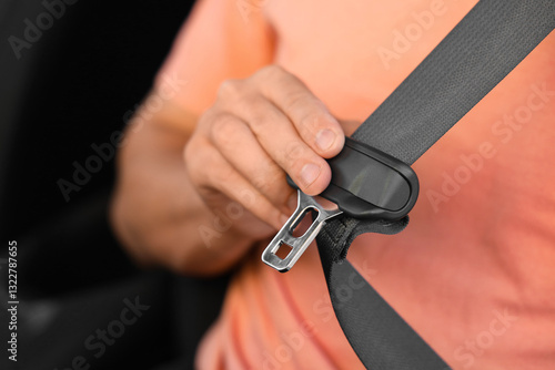 Man fastening seat belt in ...