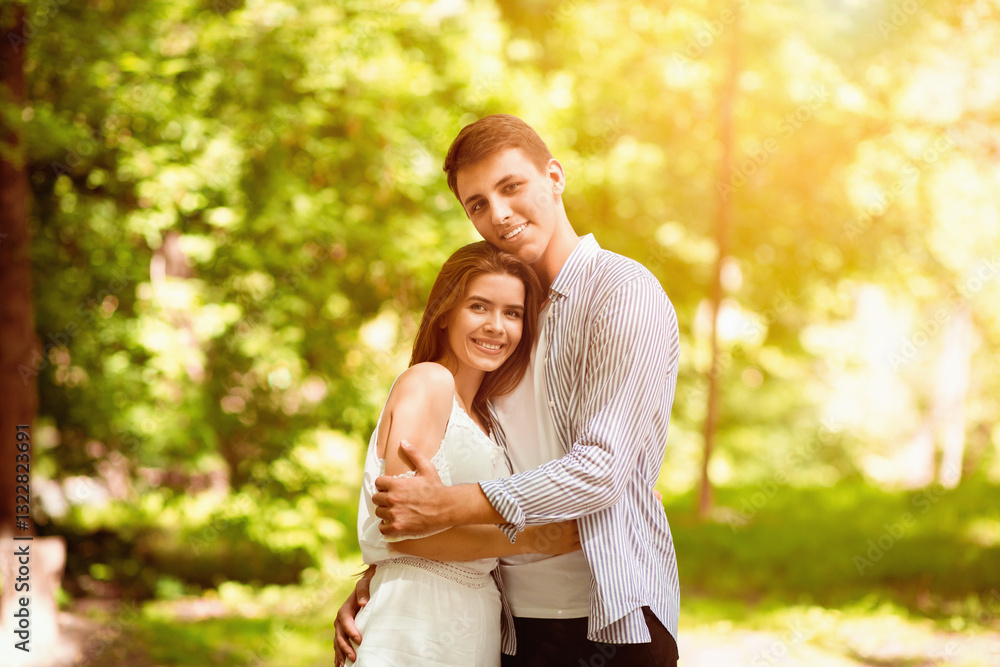 Fototapeta premium Romantic times together. Young couple in love embracing at sunny summer park