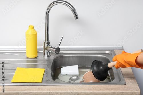 Woman cleaning clogged kitc...