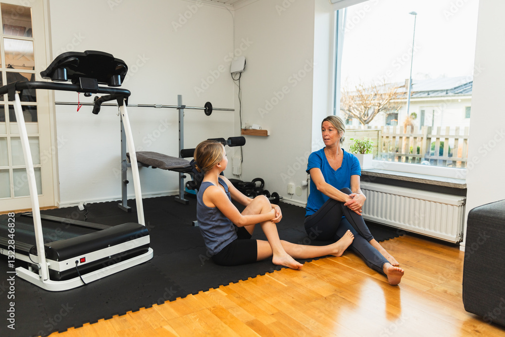 Mother and Daughter Relaxing After Workout in Home Gym Mother and Daughter Relaxing After Workout in Home Gym
