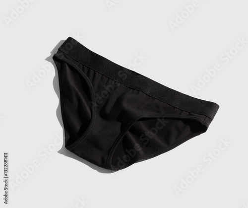 A pair of black brief style underwear on light grey background. photo