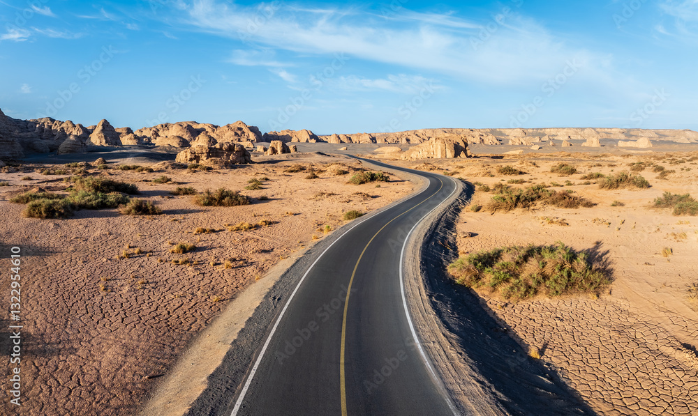 Winding road leads through the desolate Yardang landscape in Xinjiang. The famous Dahaidao no man's land natural scenery in China. Winding road leads through the desolate Yardang landscape in Xinjiang. The famous Dahaidao no man's land natural scenery in China.