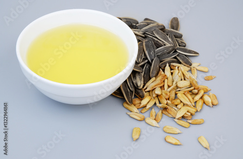 Fotografie Sunflower seeds and oil in bowl isolated on gray background