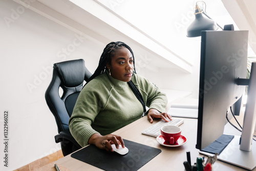 Female focused young freelancer carefully reviews a creative project