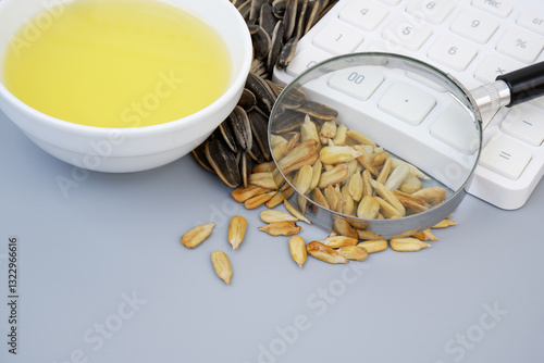 Fotografie Sunflower seeds and oil with calculator and magnifying glass