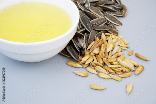 Obraz na plátně Sunflower seeds and oil in bowl on gray background close up
