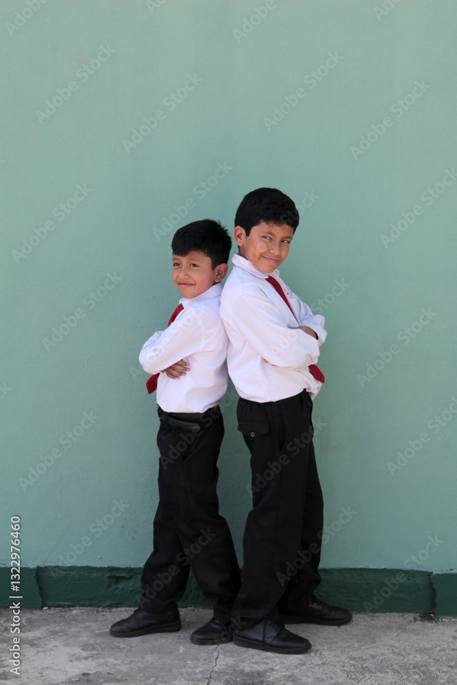 Fototapeta premium 8 and 10 year old Latino children dressed in school uniforms are happy and excited about going back to school