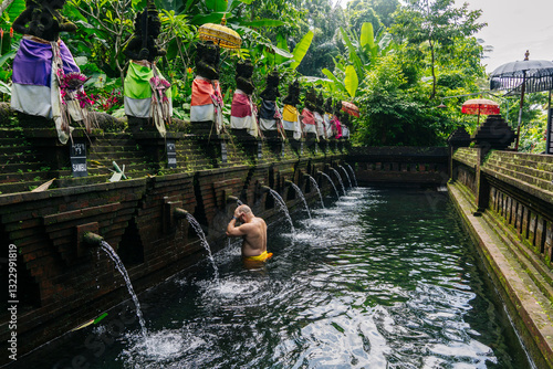 Tourist performing ritual purification with holy water in Bali