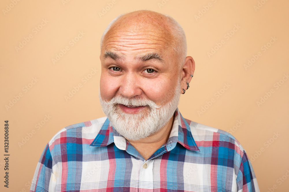 Fototapeta premium Happy and surprised old mature man face. Close-up studio portrait of senior man looking at camera. Bearded old aged man, head and shoulders portrait.