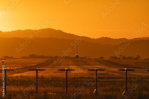 Airplane Aligned on Runway at Sunset photo