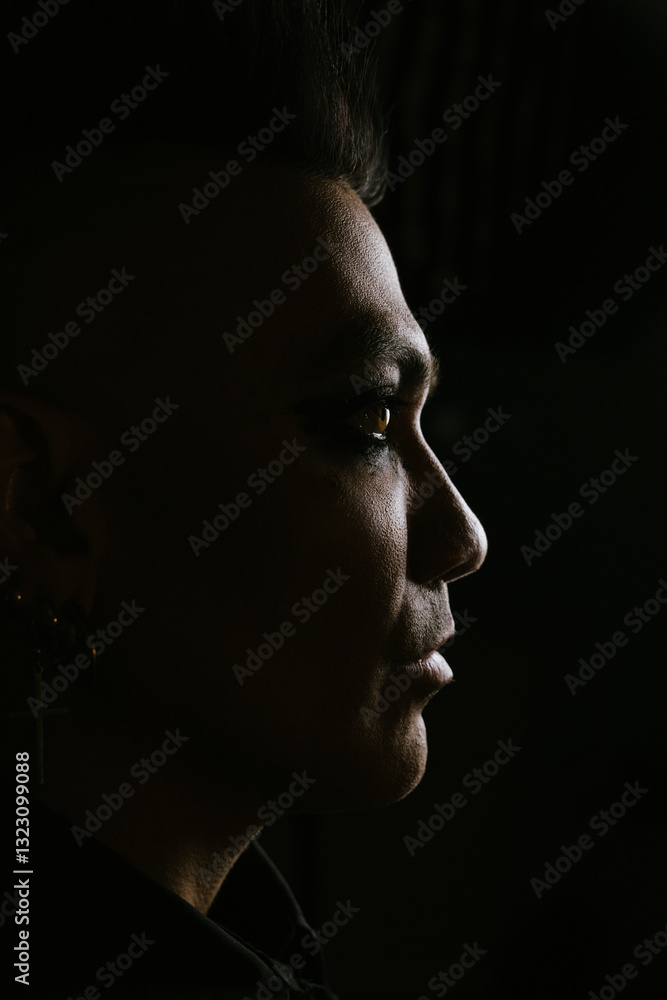 Dramatic male profile with mohawk in dark shadowy lighting Dramatic male profile with mohawk in dark shadowy lighting