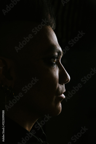 Dramatic male profile with mohawk in dark shadowy lighting