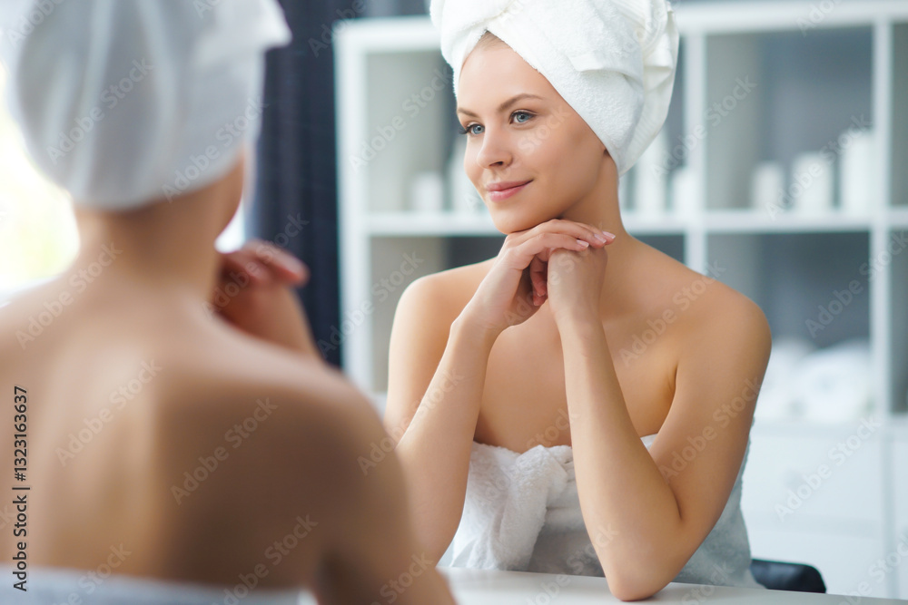 Young Girl is Sitting in front of a Make-up Mirror in the Bathroom and Applying a Skin Cream. Beautiful Woman is Making Cosmetic Rejuvenation Procedures. Young Girl is Sitting in front of a Make-up Mirror in the Bathroom and Applying a Skin Cream. Beautiful Woman is Making Cosmetic Rejuvenation Procedures.