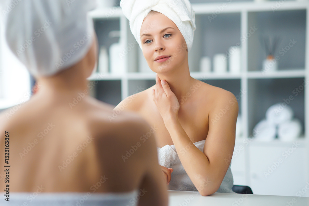 Young Girl is Sitting in front of a Make-up Mirror in the Bathroom and Applying a Skin Cream. Beautiful Woman is Making Cosmetic Rejuvenation Procedures. Young Girl is Sitting in front of a Make-up Mirror in the Bathroom and Applying a Skin Cream. Beautiful Woman is Making Cosmetic Rejuvenation Procedures.