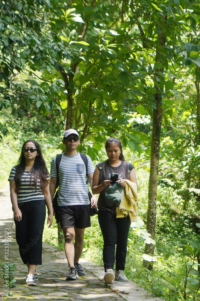 group of happy young asian indonesian people walking together on the walk path in the park group of happy young asian indonesian people walking together on the walk path in the park