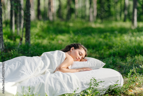 Fotografía Woman sleeps on a mattress in the summer forest