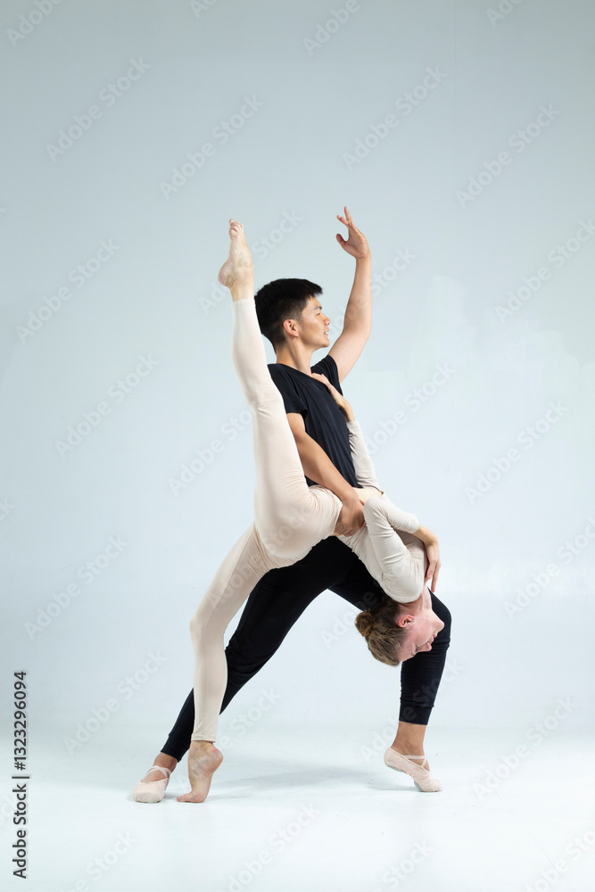 Obraz premium Sporty Asian Man and Caucasian Woman Performing As Ballet Dancers On Grey in Studio During Suppots As Classical Dance And Choreography