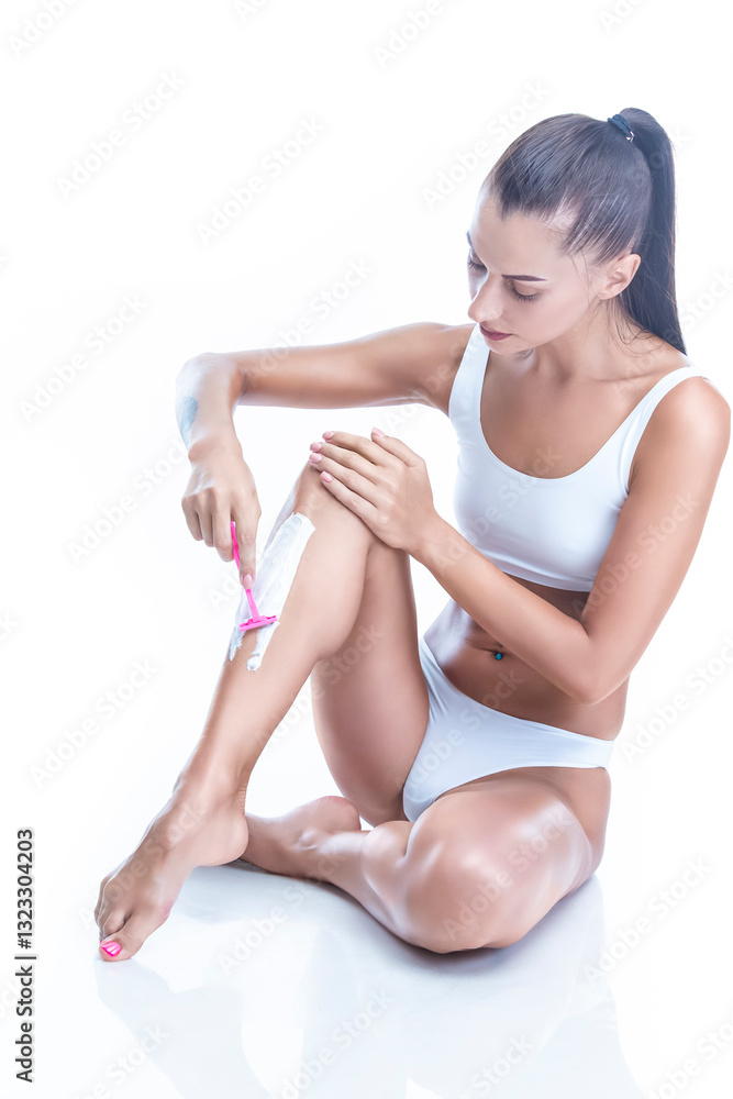 Fototapeta premium Bodycare Concepts. Full Length Portrait of Young Caucasian Winsome Woman Shaving Leg on White Background