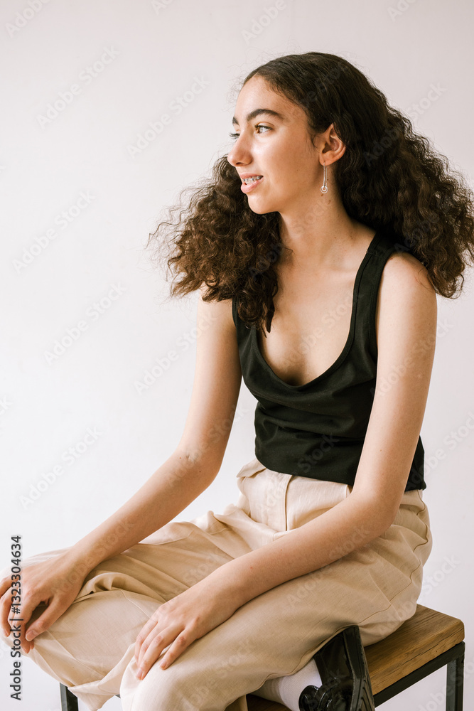 Young woman posing elegantly in a minimalist indoor setting Young woman posing elegantly in a minimalist indoor setting