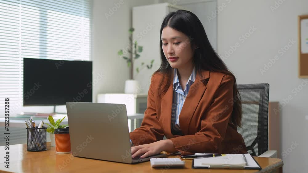 Young asian businesswoman working on laptop in office Young asian businesswoman working on laptop in office
