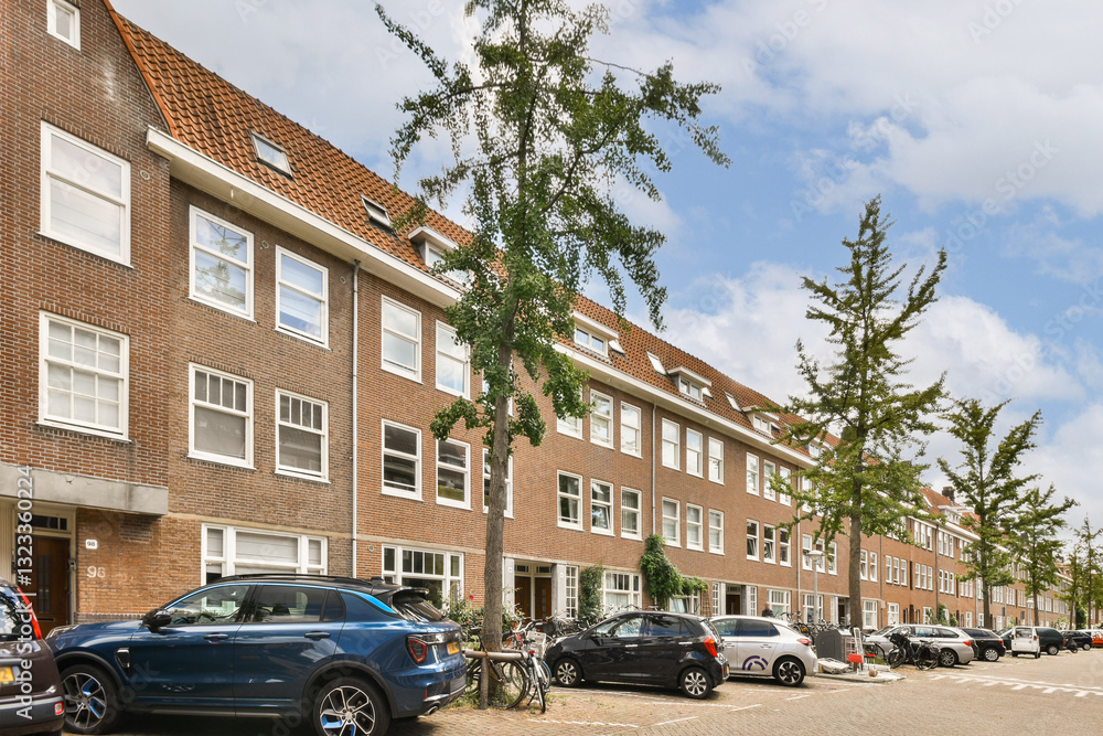 A picturesque view of a tree-lined street featuring modern residential buildings and parked cars, highlighting urban architecture and greenery. A picturesque view of a tree-lined street featuring modern residential buildings and parked cars, highlighting urban architecture and greenery.