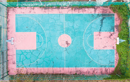Old and Weather beaten Basketball Court with Turquoise and Pink 