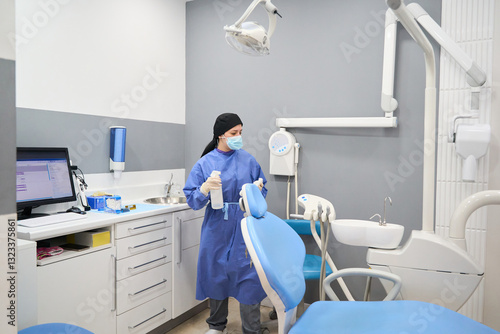 Dentist disinfecting the dental chair in a modern clinic photo