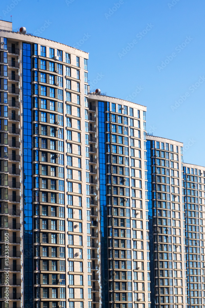 Fototapeta premium A long row of towering tall buildings with a clear blue sky in the background