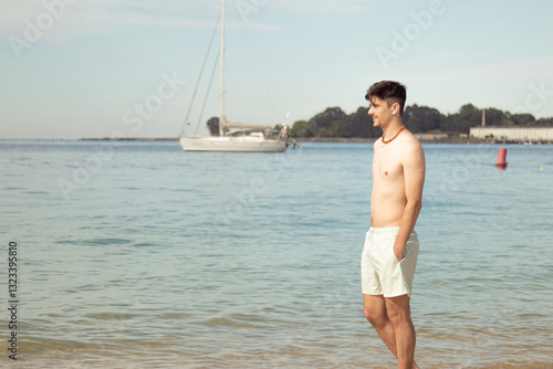 young man walking along the seashore on the beach