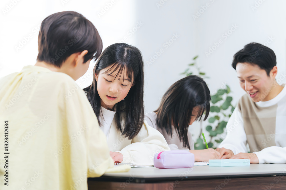 勉強する二人の女の子と指導する男女