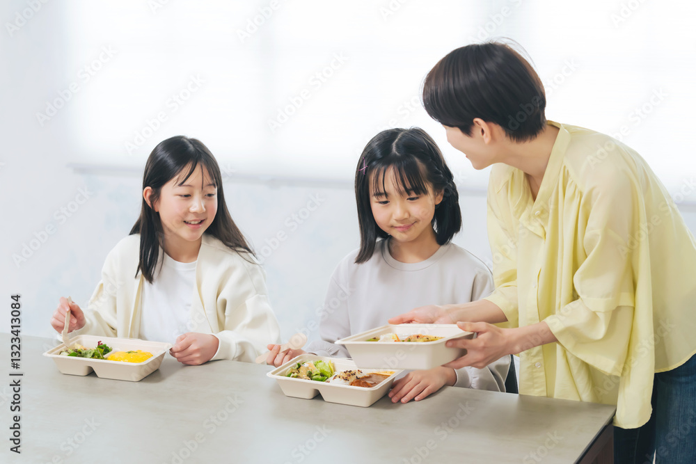 子どもにお弁当を提供する女性