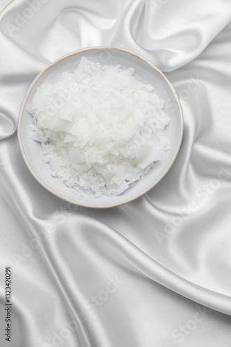 Magnesium flakes in a bowl resting on elegant white silk fabric