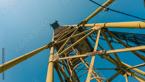 Fotografi old high metal tower building with stairs bottom view