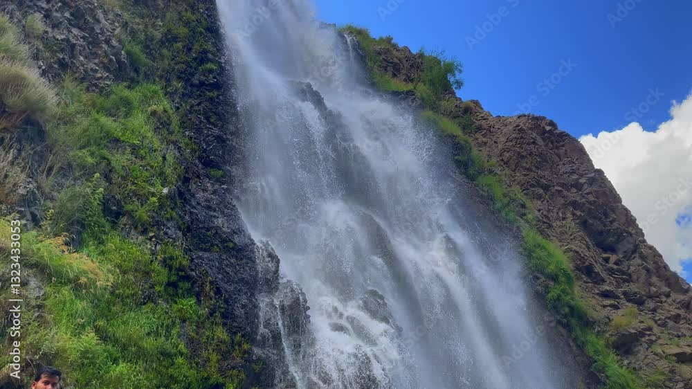 Water gracefully flowing over Manthokha Waterfall, creating a stunning natural spectacle against a backdrop of rocky cliffs and blue skies Water gracefully flowing over Manthokha Waterfall, creating a stunning natural spectacle against a backdrop of rocky cliffs and blue skies