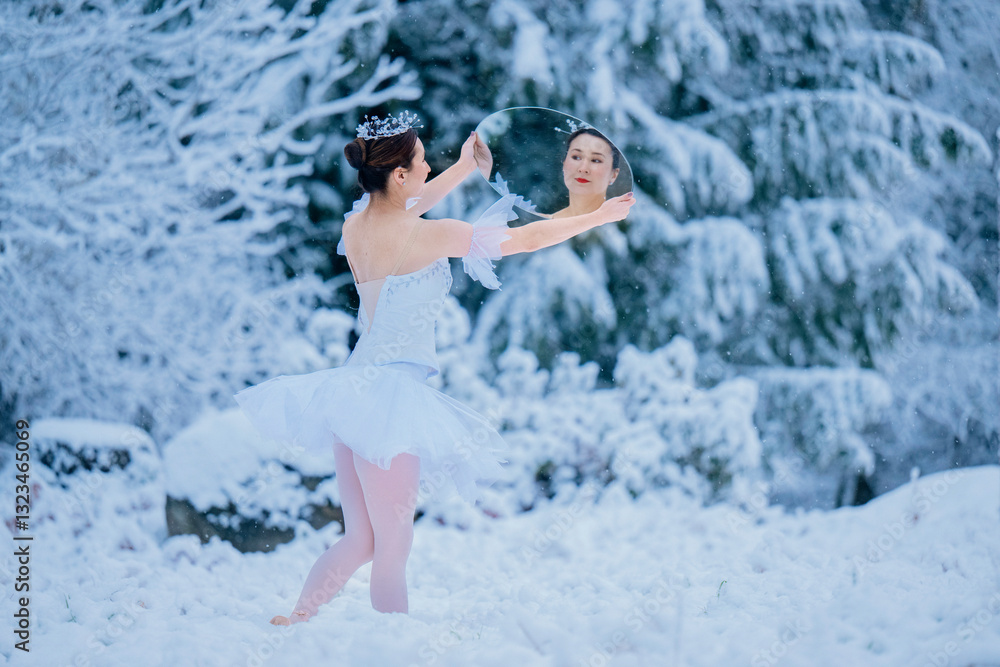 Ballerina in white tutu dancing on a snowy landscape, holding a circular mirror. WA, USA Ballerina in white tutu dancing on a snowy landscape, holding a circular mirror. WA, USA