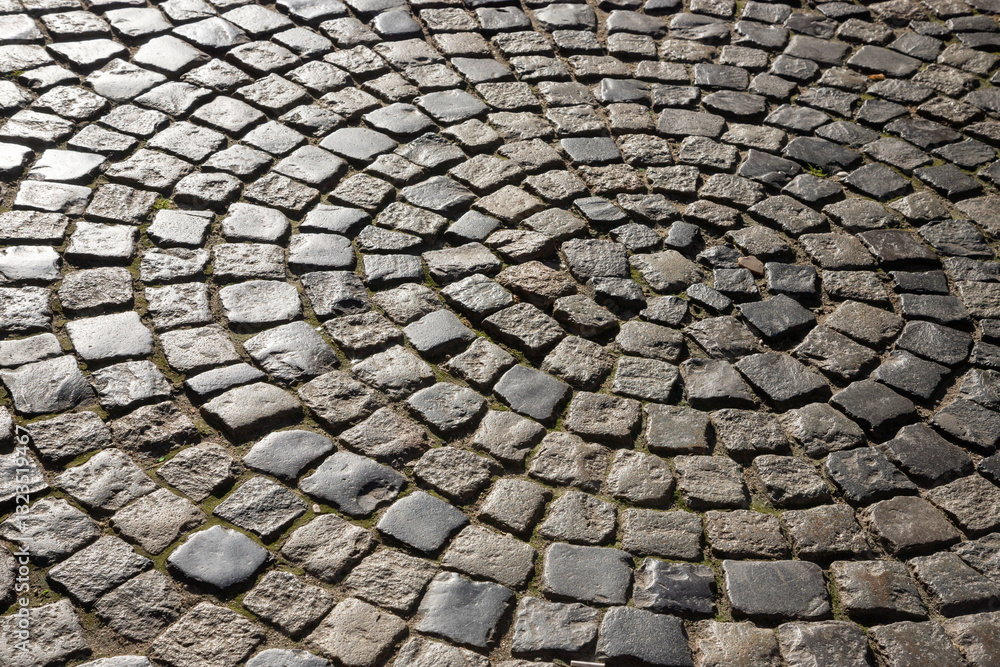 Unique cobblestone pattern on street in an old town showcasing artistic design and historical charm during daylight hours Unique cobblestone pattern on street in an old town showcasing artistic design and historical charm during daylight hours