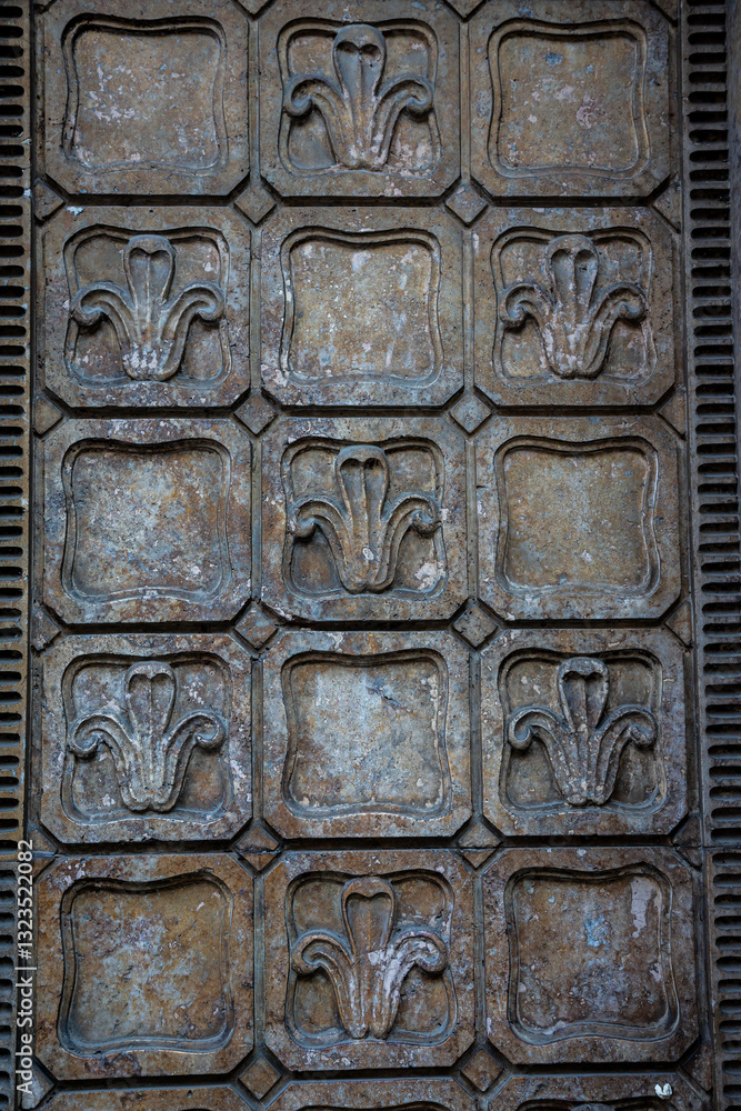 Decorative wall panel featuring floral motifs in a historic building, showcasing intricate craftsmanship and aged texture Decorative wall panel featuring floral motifs in a historic building, showcasing intricate craftsmanship and aged texture