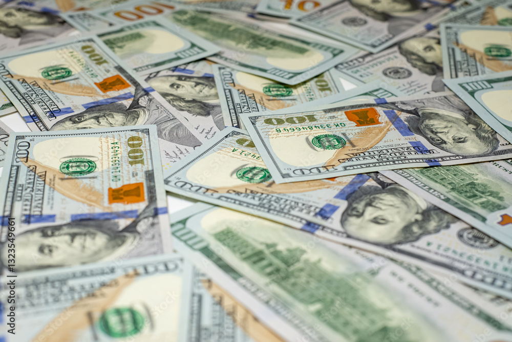 Stacks of hundred-dollar bills are spread out on a surface emphasizing the details of the new currency design side view in close up Stacks of hundred-dollar bills are spread out on a surface emphasizing the details of the new currency design side view in close up