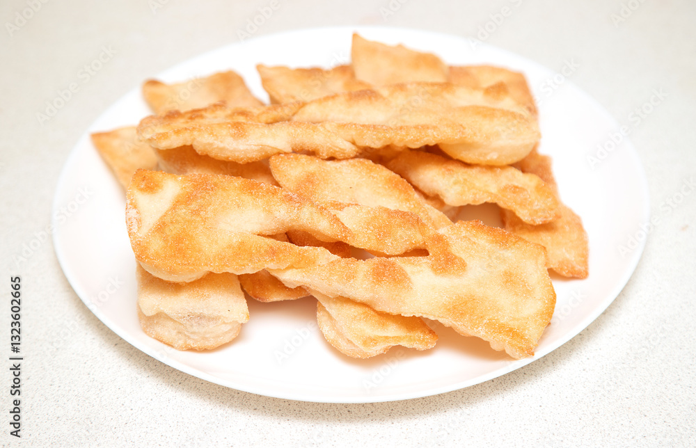 A plate of fried doughnuts sits on a counter A plate of fried doughnuts sits on a counter