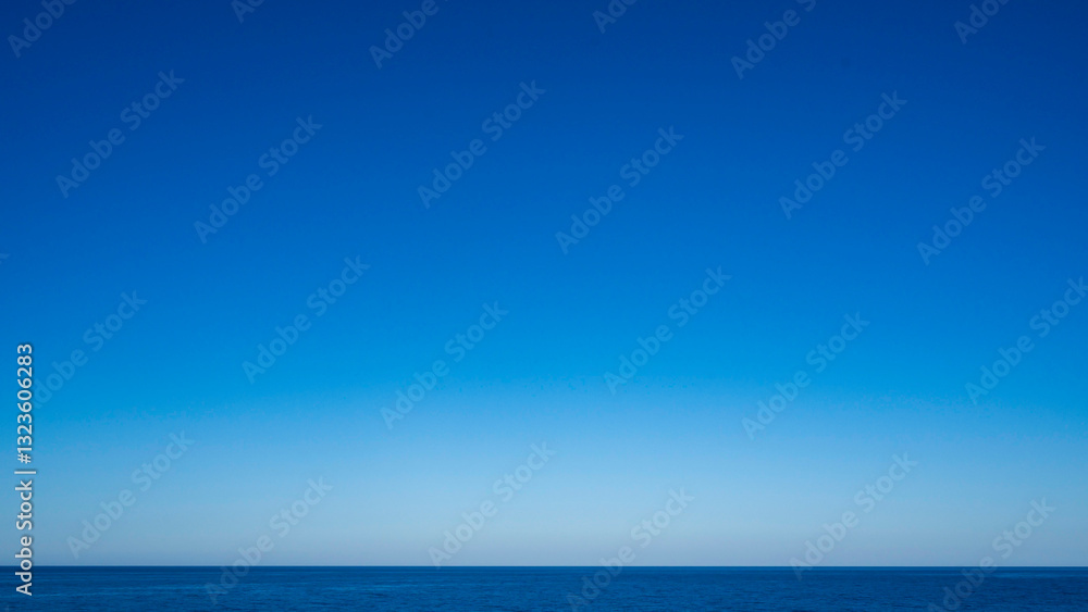 Obraz premium Calm Ocean Horizon Merging With Clear Blue Sky on A Sunny Day