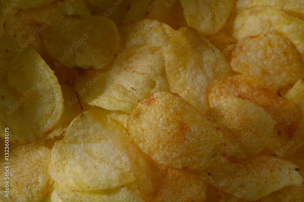 Crunchy golden potato chips piled high in a bowl, perfect for snacking at any casual gathering or party Crunchy golden potato chips piled high in a bowl, perfect for snacking at any casual gathering or party
