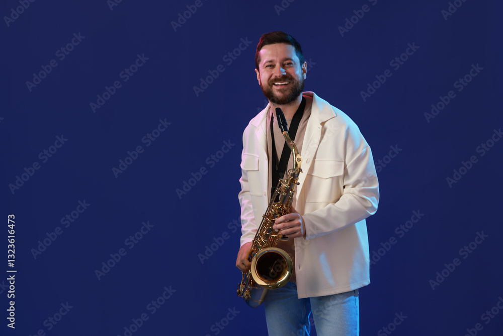 Fototapeta premium Professional musician with saxophone on blue background