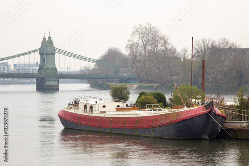 Houseboat on River Thames with Hammersmith Bridge in London

