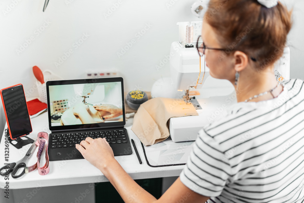Online sewing course in progress. Woman watching tutorial on laptop while working on fabric. Concept of learning new skills, handmade fashion, and digital education. Online sewing course in progress. Woman watching tutorial on laptop while working on fabric. Concept of learning new skills, handmade fashion, and digital education.