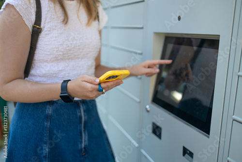 Woman using automated self service post terminal machine or locker to deposit the parcel for storage. High quality photo