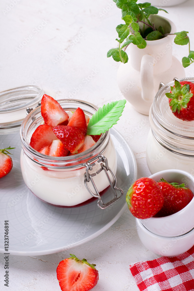 Yogurt with raspberry jam in the jar topped with strawberries on the white table. Healthy breakfast Yogurt with raspberry jam in the jar topped with strawberries on the white table. Healthy breakfast