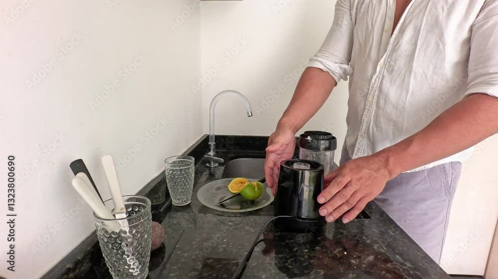 Man alone preparing healthy juice from beetroot, orange, spinach Man alone preparing healthy juice from beetroot, orange, spinach
