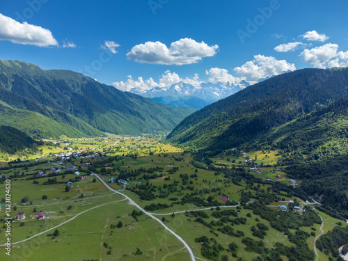 Obraz na płótnie Stunning aerial view capturing to the village in svaneti, georgia, surrounded by majestic mountains, lush valleys, and traditional svan towers w salonie
